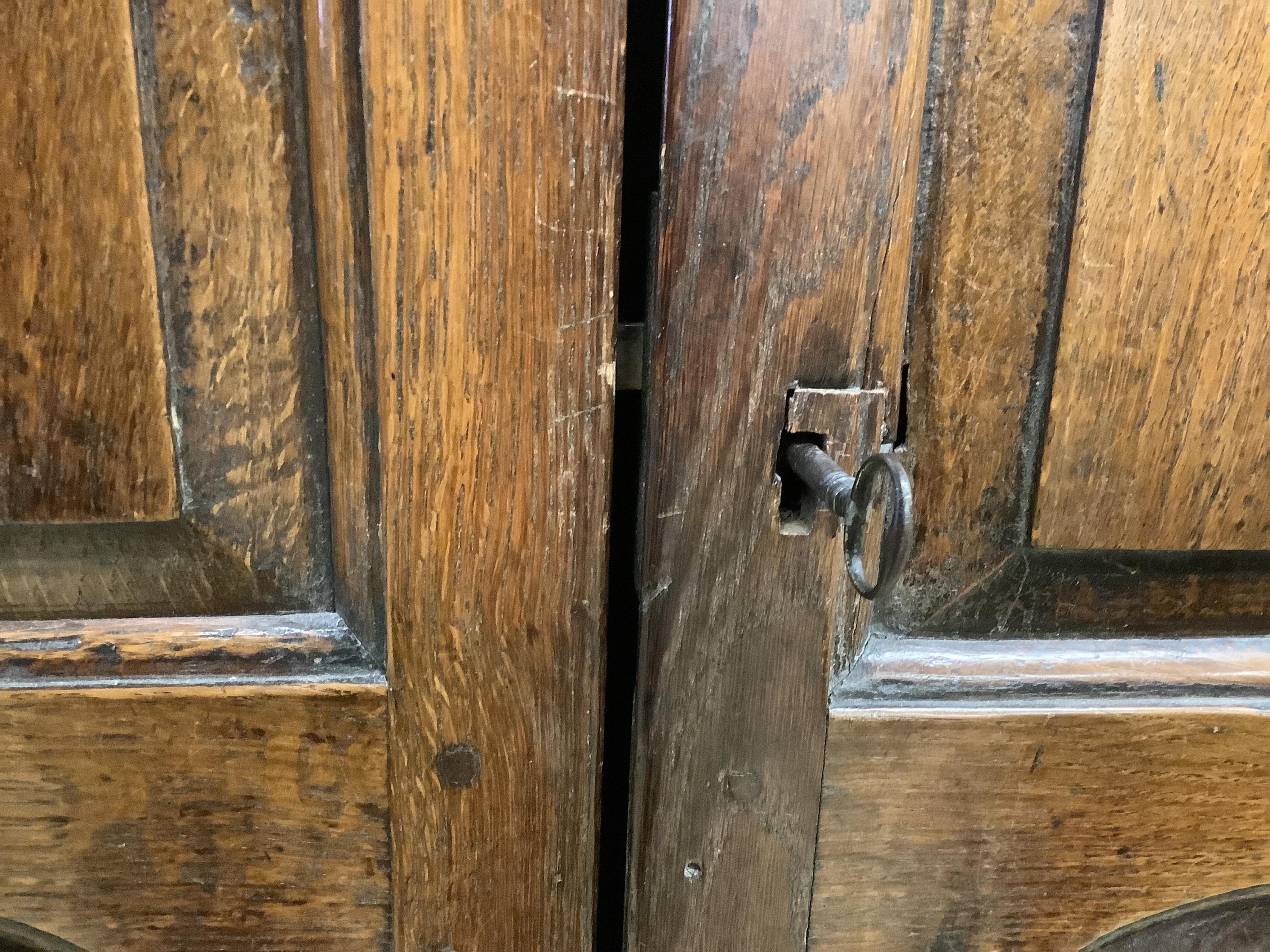 A mid 18th century carved oak cupboard, on associated stand, a.f., width 130cm, depth 55cm, height 178cm. Condition - poor